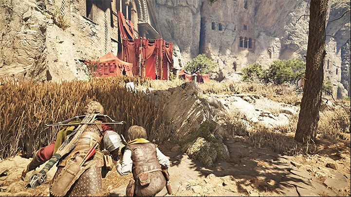 Jump down into the tall grass to the left of the main path and approach the red tent - Plague Tale Requiem: Chapter 9, Find a way around the checkpoint - walkthrough - Chapter 9 - Tales and Revelations - A Plague Tale Requiem Guide, Walkthrough