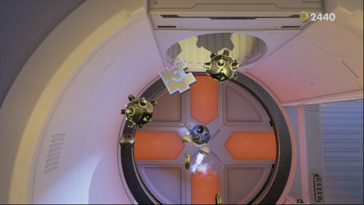 Follow the tunnel to the left, avoiding the electrified cables and orb-spitting opponents until you reach a circular room with orange elements on the wall - Astros Playroom: Orbital Obstacles - walkthrough - SSD Highway - Astros Playroom Guide