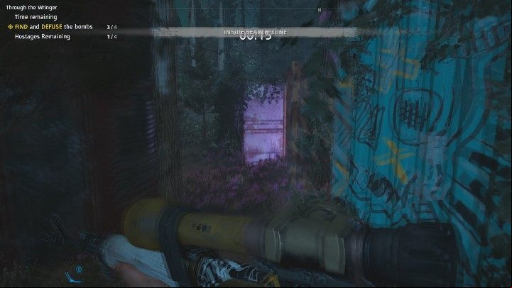 The last bomb is in the orange container, the one between the blue and the pink one - Through the Wringer | Far Cry New Dawn Walkthrough - Story Missions - Far Cry New Dawn Guide