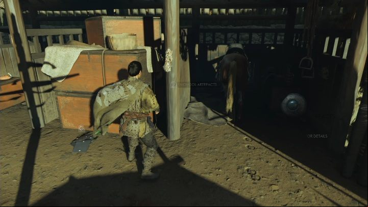 This Mongol artifact is hanging on a pole in the stables - Ghost of Tsushima: Mongol artifacts - secrets, missables, video guide - Secrets and collectibles - Ghost of Tsushima Guide, Walkthrough