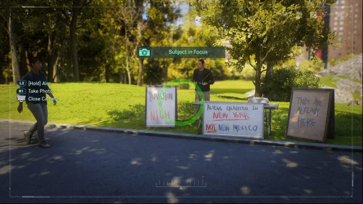 Go to the northern part of the park and take a picture of the man standing by the signs about aliens in New Mexico - Spider-Man 2: All Photo Ops - locations - Secrets and Collectibles - Spider Man 2 Guide