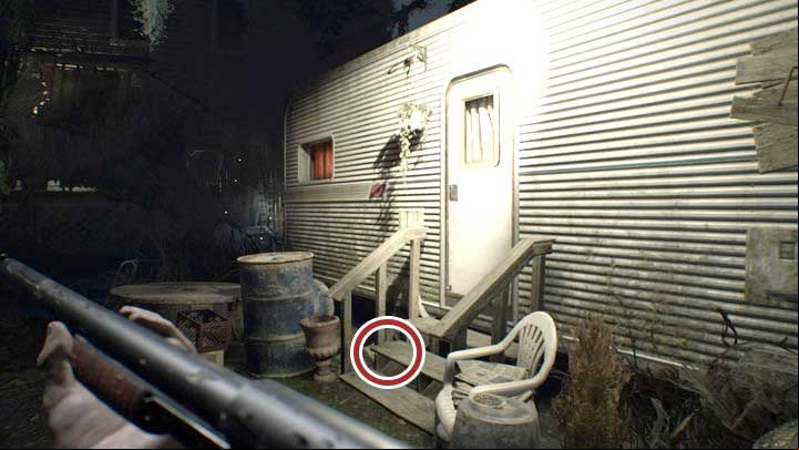 The statuette can be found between the stairs leading to the trailer. - Resident Evil 7: Old House, Yard, Greenhouse Map - Secrets - Secrets and Maps - Resident Evil 7 Guide, Walkthrough